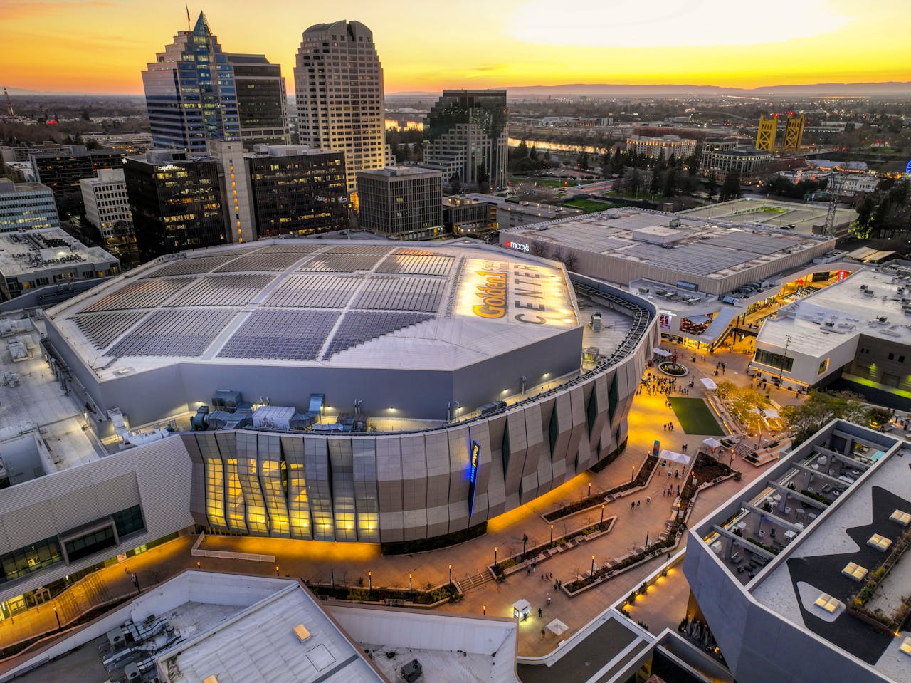 Captivating aerial view of Golden 1 Center and Sacramento skyline at sunset.