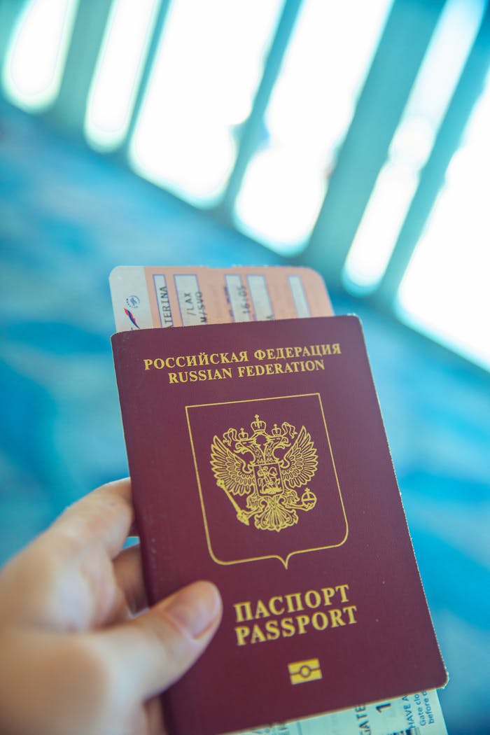 Home Russian passport held in hand with boarding pass peeking out, ready for travel.