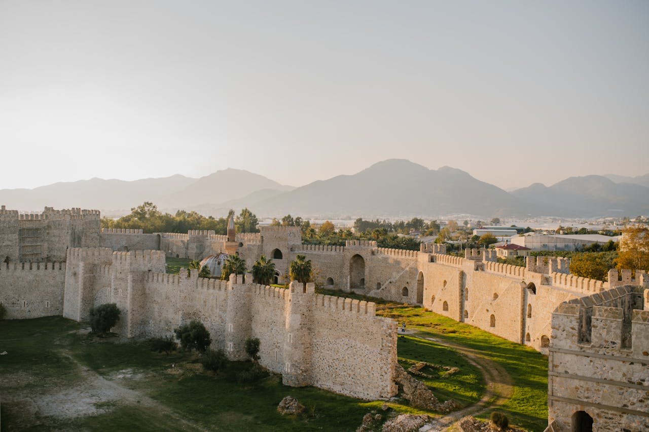 Stunning aerial view of historical fortress walls with mountains in Alanya, Turkey.